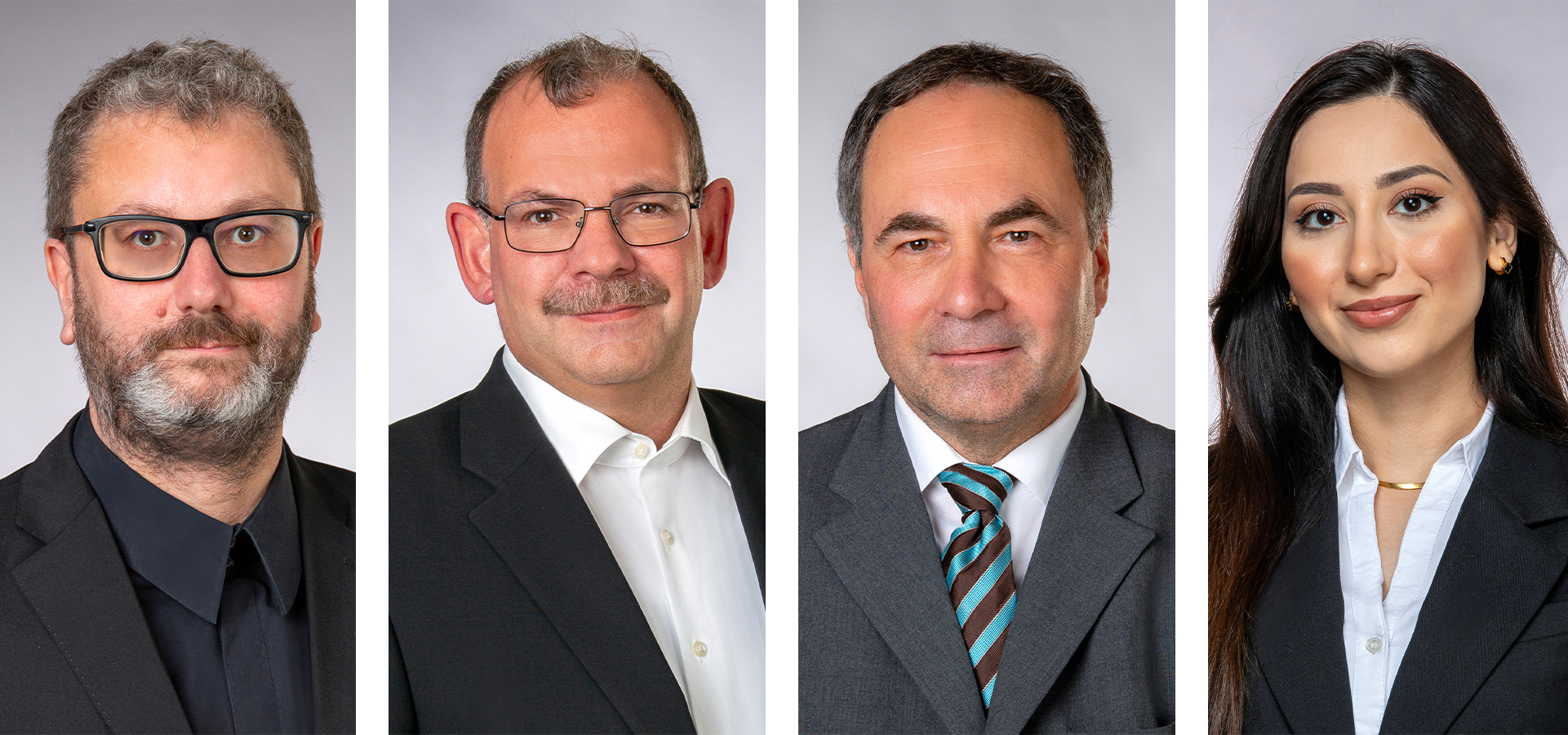 Vier professionell gekleidete Erwachsene, drei Männer und eine Frau, posieren für formelle Kopfschüsse vor einem hellgrauen Hintergrund. Jeder trägt eine Anzugsjacke und ein Hemd mit Kragen und schaut direkt in die Kamera.